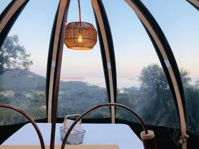 a chandelier hanging over a table in front of a window at Palom'bolla in Porto-Vecchio