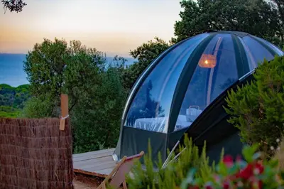 a dome tent in a garden with a wooden table at Palom'bolla in Porto-Vecchio