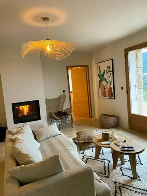 a living room with a couch and a fireplace at Stone Sheepfold With Sea View In Corsica in Sari-dʼOrcino
