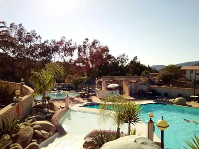 a large swimming pool in a resort with mountains in the background at Chalet 3 étoiles - Piscine - ccb0fdc in Viggianello