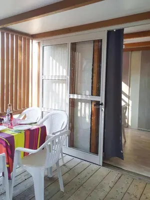 a table and chairs in a room with a balcony at Chalet 3 étoiles - Piscine - ccb0fdc in Viggianello