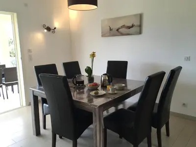 a dining room table with black chairs and a table at Locations I Carboni - villa 2 chambres in Sollacaro