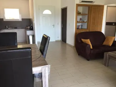 a kitchen and living room with a table and a couch at Locations I Carboni - villa 2 chambres in Sollacaro