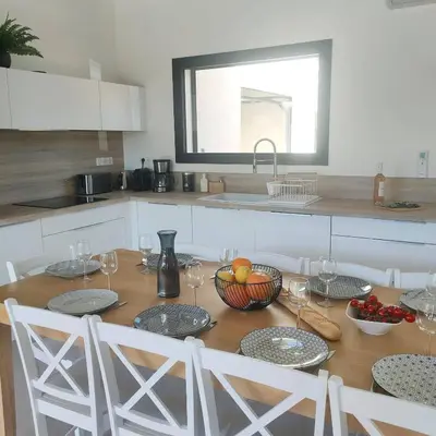 a kitchen with a wooden table with bowls of fruit at suara in Pinarellu