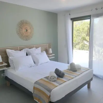 a bedroom with a large bed with towels on it at suara in Pinarellu