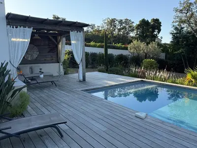 a wooden deck with a pool and a pergola at suara in Pinarellu