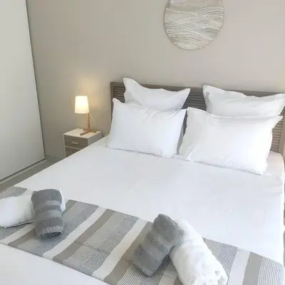 a bedroom with a white bed with towels on it at suara in Pinarellu