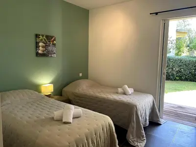 a bedroom with two beds and a sliding glass door at t3cj n14 in Pinarellu