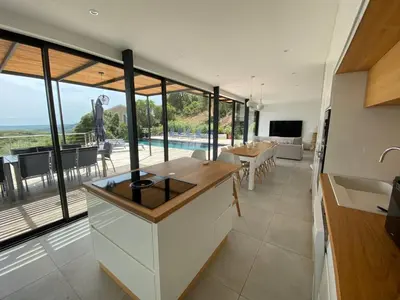a kitchen with white cabinets and a table and chairs at Rostalana in Pinarellu