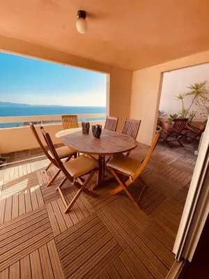 a dining room with a table and chairs on a balcony at Ajaccio sanguinaires F3 in Ajaccio