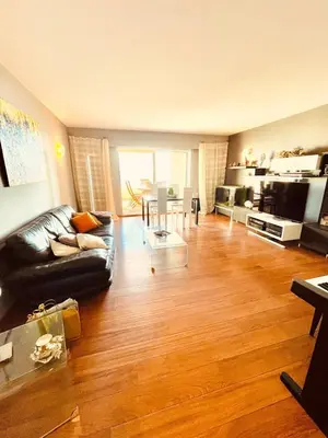 a living room with a black couch and a wooden floor at Ajaccio sanguinaires F3 in Ajaccio