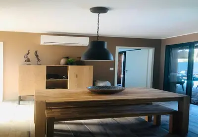 a dining room with a wooden table in a room at alcudina in Zonza