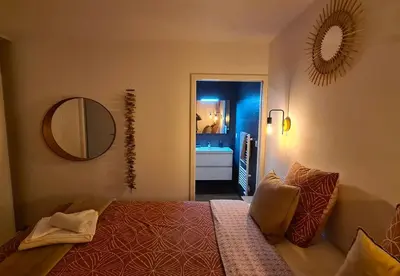 a bedroom with a bed and a mirror and a bathroom at alcudina in Zonza