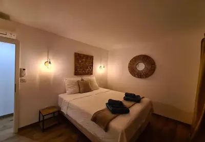 a bedroom with a bed with two bags on it at alcudina in Zonza