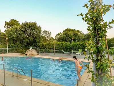 a woman in a bikini standing in a swimming pool at U Pinarellu in Zonza