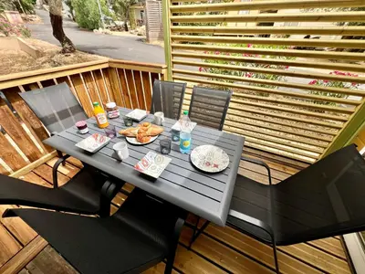 a black table with food on top of a deck at Chalet A tout confort à deux pas des plages in Pianottoli-Caldarello