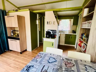 a small kitchen with a table and chairs in a room at Chalet A tout confort à deux pas des plages in Pianottoli-Caldarello