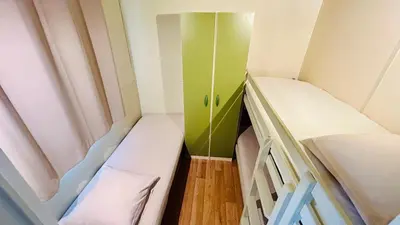 a small room with two beds and a green cabinet at Chalet A tout confort à deux pas des plages in Pianottoli-Caldarello