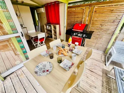 a table and chairs in a room with a kitchen at Chalet N tout confort à deux pas des plages in Pianottoli-Caldarello