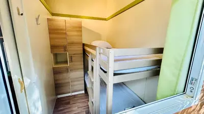 a small room with a bunk bed in a tiny house at Chalet N tout confort à deux pas des plages in Pianottoli-Caldarello
