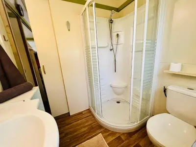 a bathroom with a shower and a toilet at Chalet N tout confort à deux pas des plages in Pianottoli-Caldarello