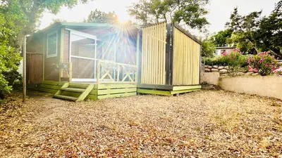 a green tiny house sitting in a yard at Chalet N tout confort à deux pas des plages in Pianottoli-Caldarello