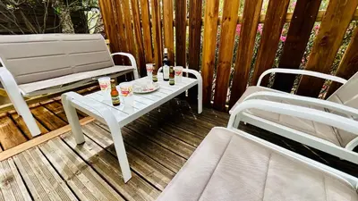 a white table with drinks and two chairs on a patio at Chalet M tout confort proche des plages in Pianottoli-Caldarello