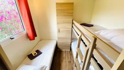 a small room with two bunk beds and a window at Chalet M tout confort proche des plages in Pianottoli-Caldarello