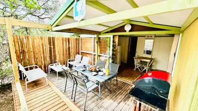 a patio with a table and chairs on a deck at Chalet M tout confort proche des plages in Pianottoli-Caldarello