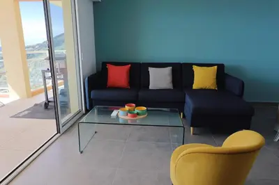 a dining room and living room with a table and chairs at Acula Marina - Mer, Maquis Corse - T4 Lumineux in Ajaccio