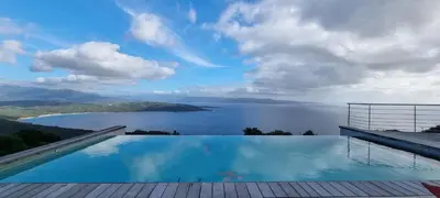 a swimming pool with a view of a body of water at Villa de standing piscine chauffée vue mer Corse du sud in Coti-Chiavari