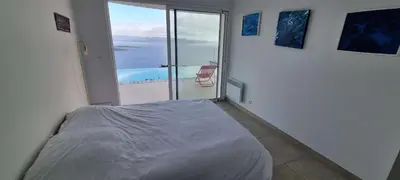 a bedroom with a bed and a view of the ocean at Villa de standing piscine chauffée vue mer Corse du sud in Coti-Chiavari