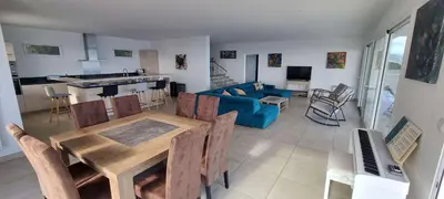 a living room with a table and a blue couch at Villa de standing piscine chauffée vue mer Corse du sud in Coti-Chiavari