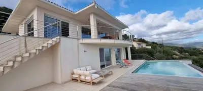 a house with a swimming pool and a balcony at Villa de standing piscine chauffée vue mer Corse du sud in Coti-Chiavari