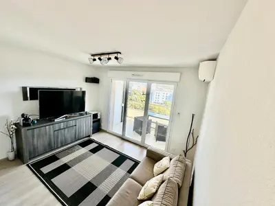 a living room with a couch and a flat screen tv at Ajaccio Apartment STUDIO in Ajaccio