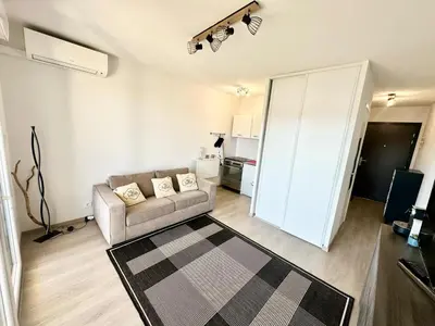 a living room with a couch and a kitchen at Ajaccio Apartment STUDIO in Ajaccio