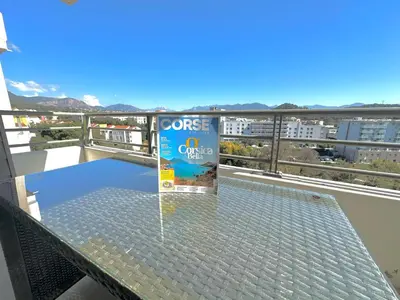 a glass table on a balcony with a view at Ajaccio Apartment STUDIO in Ajaccio