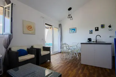 a living room with a kitchen and a dining room at Duplex 2 chambres, vue mer & balcon - 6 couchages in Porticcio