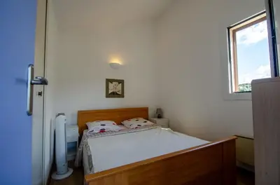 a bedroom with a bed in a room with a window at Duplex 2 chambres, vue mer & balcon - 6 couchages in Porticcio