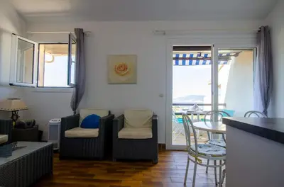 a living room with a couch and a table with chairs at Duplex 2 chambres, vue mer & balcon - 6 couchages in Porticcio