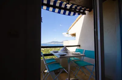 a table and chairs on a balcony with a view at Duplex 2 chambres, vue mer & balcon - 6 couchages in Porticcio