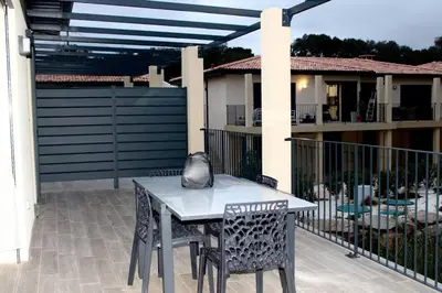 a table and chairs on a patio in front of a building at 9D - appartement Bonifacio Corse in Bonifacio