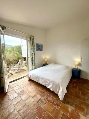a bedroom with a bed and a large window at Villa Gardelina in Campomoro