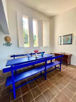 a blue bench in a room with a table at Villa Gardelina in Campomoro