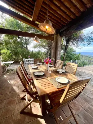 a wooden table and chairs on a patio at Villa Gardelina in Campomoro
