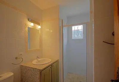 a bathroom with a sink and a shower with a mirror at A Machja 17 in Monacia-dʼAullène