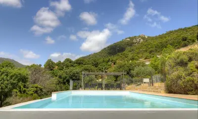 a swimming pool with a mountain in the background at A Machja 17 in Monacia-dʼAullène