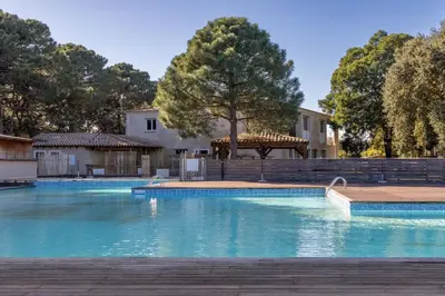 a swimming pool with blue water in front of a building at fior di cala rossa in Lecci