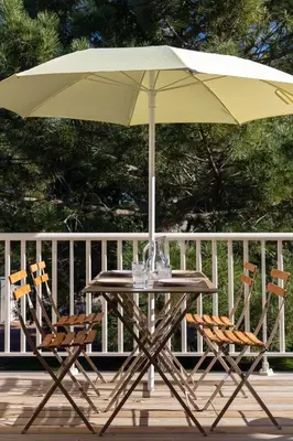 a table and two chairs under an umbrella on a deck at fior di cala rossa in Lecci