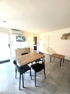 a dining room with a wooden table and chairs at Les hameaux de Saint Cyprien - appartement avec jardin et piscine in Lecci